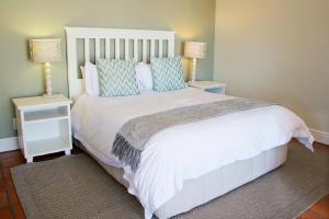 
a bedroom with a white bedspread and white pillows at First Avenue Guesthouse in Port Elizabeth
