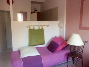グリュイッサンにあるLa planqueの紫と緑のシーツが備わるベッド1台