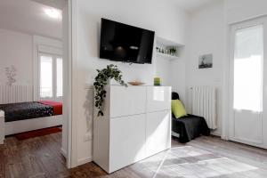 a white living room with a tv on a wall at StayEasy Filzi11 - 3 Bedrooms, 2 baths - Central Station in Milan