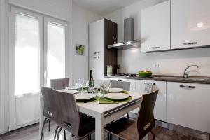 biała kuchnia ze stołem i kieliszkami do wina w obiekcie StayEasy Filzi11 - 3 Bedrooms, 2 baths - Central Station w Mediolanie