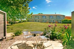 un patio con mesa y sillas frente a un edificio en Alloggio Bathurst, en Bathurst