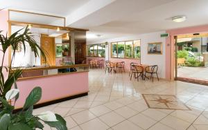 - un hall d'un restaurant avec des chaises et des tables dans l'établissement Hotel Levante, à Cervia