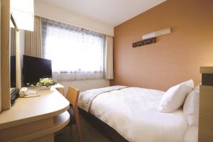 Un pat sau paturi într-o cameră la Karasuma Kyoto Hotel