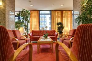 a waiting room with leather chairs and a table at Centro Park Hotel Berlin-Neukölln in Berlin