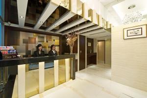 duas mulheres em pé num balcão na entrada de um hotel em Pop Inn Mong Kok em Hong Kong