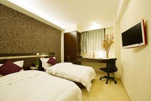 a hotel room with two beds and a desk at Pop Inn Mong Kok in Hong Kong