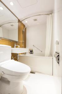 a bathroom with a toilet and a bath tub at Hotel Mystays Gotanda Station in Tokyo