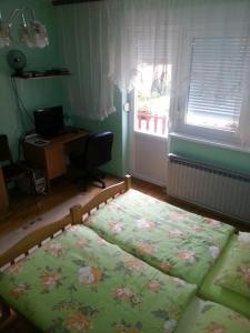 a bedroom with two beds and a desk and a window at Setnik Guesthouse in Valpovo