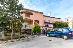 Niebieski samochód zaparkowany przed budynkiem w obiekcie Apartments Gloria w mieście Ližnjan