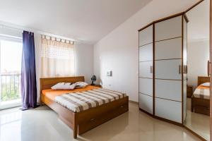 sypialnia z łóżkiem i szklaną szafką w obiekcie Apartments Gloria w mieście Ližnjan