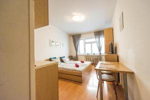 a bedroom with a bed and a table and a desk at Apartments Presidential Palace in Bratislava