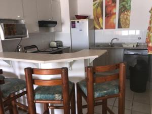 a kitchen with a table and two chairs and a sink at Laguna la crete unit X in Uvongo Beach
