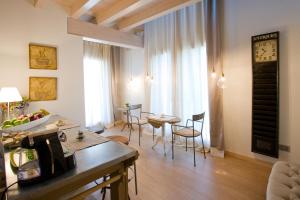 マーロにあるLocanda Ristorante da Umbertoのリビングルーム(テーブル、椅子、時計付)