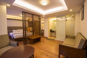 una camera da letto con un letto, un tavolo e un divano di Potala Guest House a Kathmandu