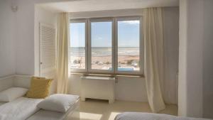a bedroom with a window with a view of the ocean at Casa De Mare in Olimp +117 photos