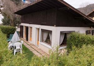 a house with a table and a chair in front of it at Le Petit Chalet in Morzine