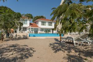 a house on the beach with chairs and trees at Casa De Mare in Olimp
