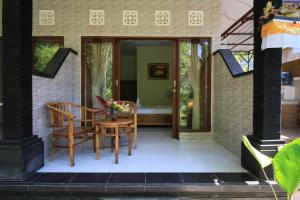 a patio with a table and chairs on a house at Teba Jati Guest House in Ubud