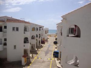 eine Gasse zwischen zwei Gebäuden mit dem Meer im Hintergrund in der Unterkunft Alquileres Cap y Corp in Alcossebre
