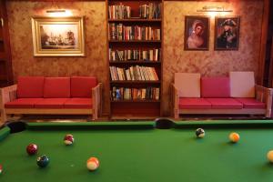 a living room with a pool table and two couches at The Lord Nelson Hotel in Ban Chang