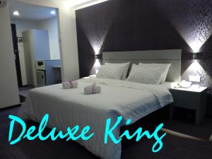 ein Schlafzimmer mit einem großen weißen Bett mit blauem Licht in der Unterkunft Muar Traders Hotel in Muar