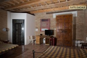 1 dormitorio con 1 cama y escritorio con TV en Hotel Palazzo Meraviglia Albergo diffuso, en Corinaldo