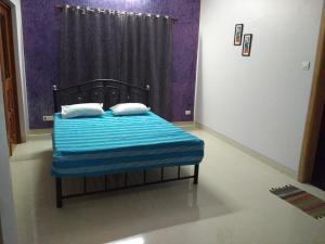 1 cama con 2 almohadas en una habitación en Jeevan Geet, en Alibaug