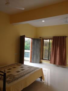1 dormitorio con cama y ventana grande en Jeevan Geet, en Alibaug