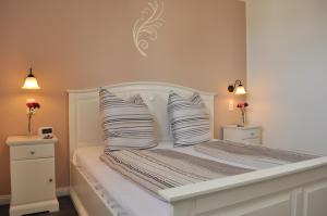 ein Schlafzimmer mit einem weißen Bett mit zwei Kissen in der Unterkunft Ferienwohnungen Gehlberg in Gehlberg