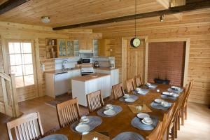 a kitchen and dining room with a table and chairs at Ahmalammen mökkikylä in Kauhajoki