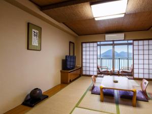 uma sala de estar com uma mesa e uma janela em Toya Kohan Tei em Lago Tōya