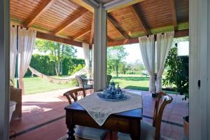 ein Esszimmer mit einem Tisch und Stühlen auf einer Veranda in der Unterkunft Villa Bellaria B&B in Alseno