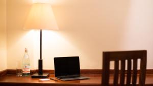 a laptop computer sitting on a desk with a lamp at 254 Ole Sereni-Nairobi Park View in Nairobi