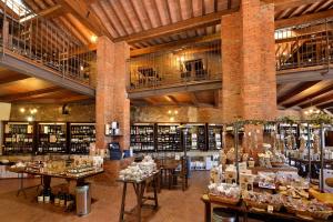 モンテプルチャーノにあるLa Corte Mediceaのテーブルとワインのボトルが備わる広い客室です。