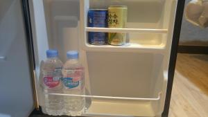 an open refrigerator filled with bottles of water at Hotel Prince in Busan