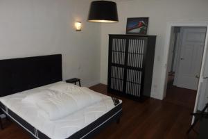 - une chambre avec un lit doté de draps blancs et d'une lampe dans l'établissement Appartement Meurisse 7, à Metz