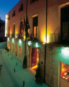 un edificio con luces en el lateral. en Sercotel Palacio de Tudemir, en Orihuela