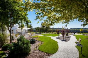 un jardín con un banco, árboles y césped en Gościniec Nad Gopłem, en Grodztwo