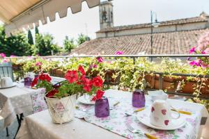 a table with flowers in vases on a balcony at Terrazza Ginori in Sesto Fiorentino