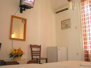 een kamer met een televisie, een tafel en een koelkast bij Hotel Maroulis in Naxos Chora
