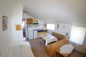 een woonkamer met een tafel en een keuken bij Apartments Kreso in Fažana