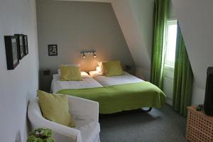 een kamer met 2 bedden, een bank en een raam bij Strandhotellet in Öregrund