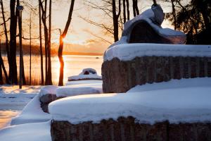 een rij banken bedekt met sneeuw bij zonsondergang bij Hotel Hanasaari in Espoo