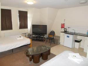 a hotel room with a bed, desk and television at Hotel Citystay in London