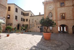 a courtyard with a building with a clock tower at B&B Tre Finestre sul Mare in Grottammare