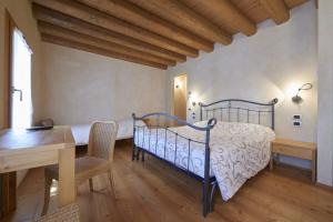 1 dormitorio con 1 cama, mesa y sillas en Agriturismo la paterna, en Giavera del Montello