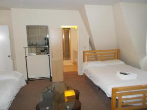 a room with two beds and a glass table at Citystay Hotel in London