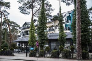 a building on the corner of a street with trees at Hotel Morskie Oko in Jurata