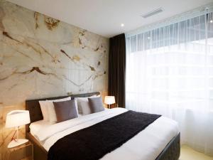 a bedroom with a large bed and a stone wall at VISIONAPARTMENTS Wolframplatz - contactless check-in in Zurich