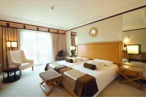 a hotel room with a large bed and a chair at Grande Real Villa Itália Hotel & Spa in Cascais